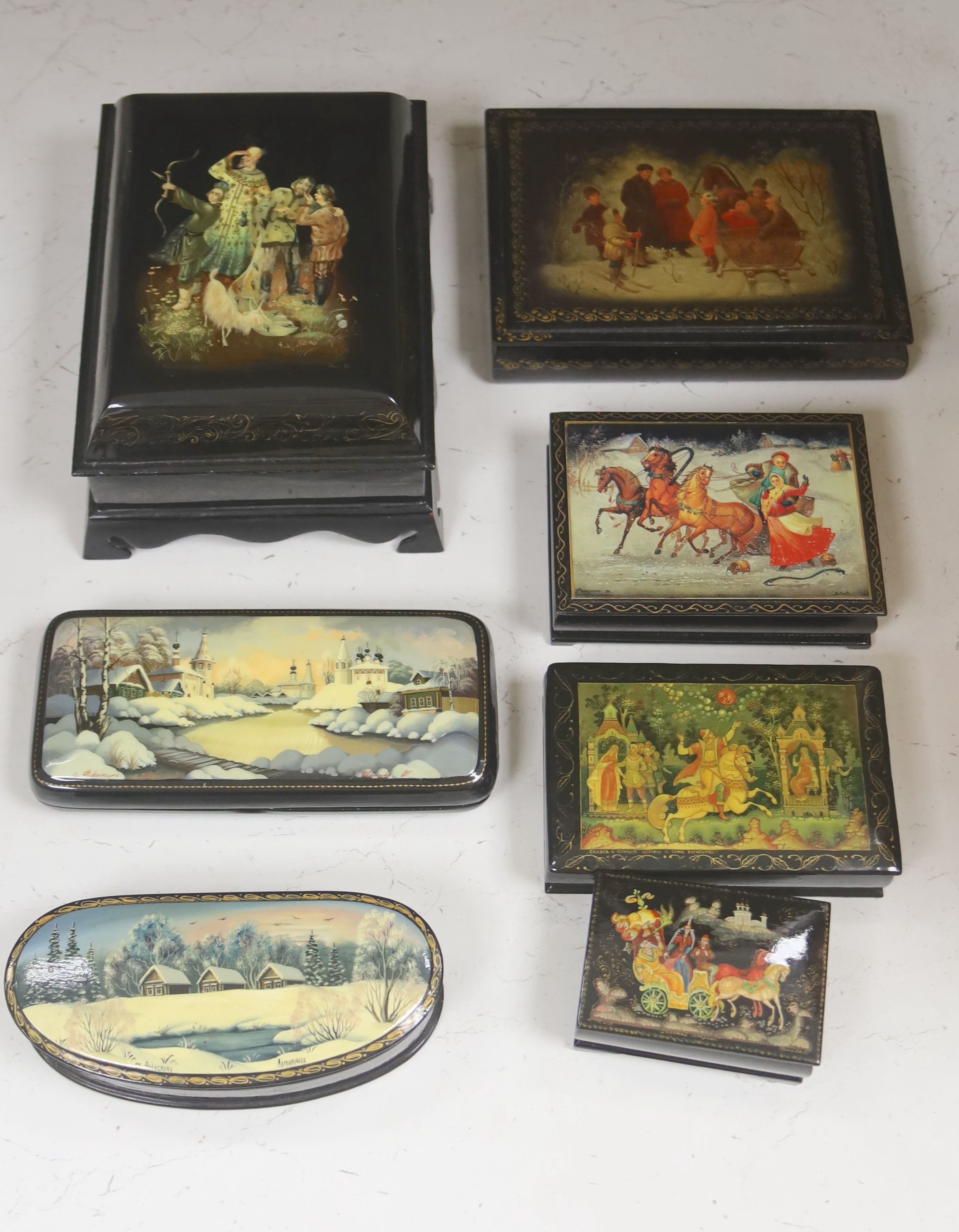 A collection of seven Russian painted lacquer boxes, largest raised on bracket base 15 x 20cm 9.5cm high